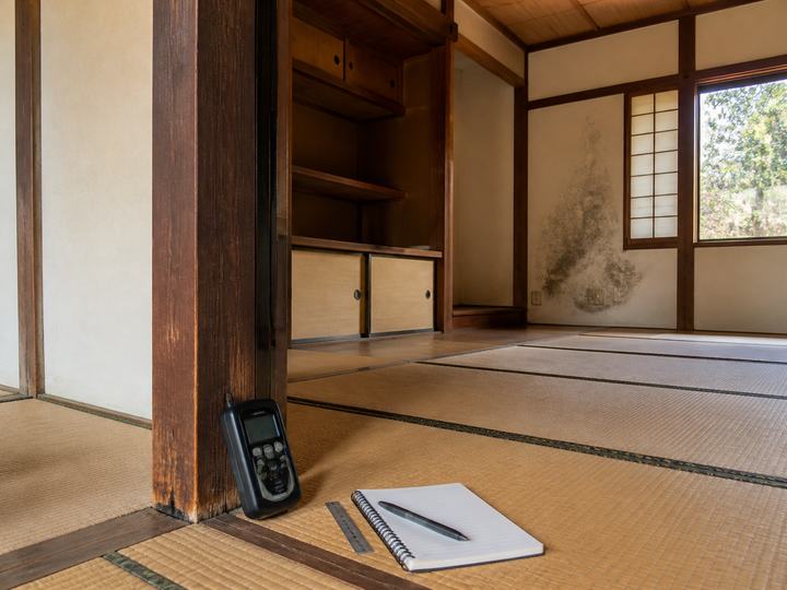 古家の室内で柱や壁の状態を記録する場面